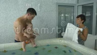 父亲和小儿子完成了儿童游泳池的用水程序