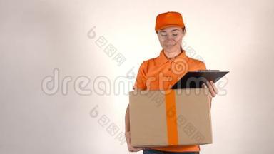 穿橙色制服的女孩<strong>快递</strong>员<strong>送</strong>了一个大纸箱。 浅灰色背景，4K摄影棚拍摄