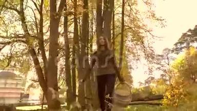 布鲁内特女孩走在秋天的森林里，拿着一个篮子。 4K型安定片