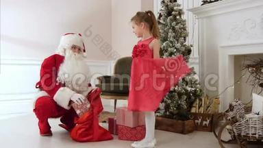 <strong>圣诞老人送礼物</strong>给漂亮的小女孩，拥抱她