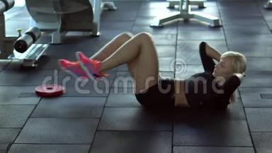 年轻女子在健身房里摇着地板上的压力