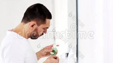 带有化妆水或爽肤水的男人在浴室里