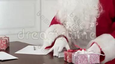 圣诞老人坐在他的桌子上给圣诞老人回信