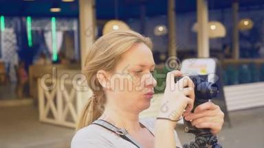 一个职业<strong>摄影</strong>师在<strong>游乐园</strong>拍照，一个女人在开花间按下一个小玩意的按钮