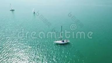 美丽的史诗级无人驾驶飞机空中镜头温暖的晴天在蓝色开阔的海洋，白色专业游艇在赛车