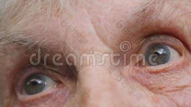 特写老妇人抬头的肖像。 一位有皱纹的老太太的眼睛。 慢动作