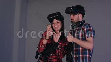 笑着的一对虚拟现实中的情侣看着他们手机上的搞笑照片