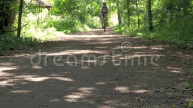 运动员男子骑自行车穿过森林。 健康的生活方式。