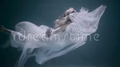 穿着白色裙子在水下游泳的年轻美女