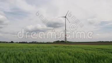 两个风车在一个麦田后面的大风中