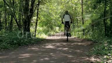 运动员男子骑自行车穿过森林。 健康的生活方式。
