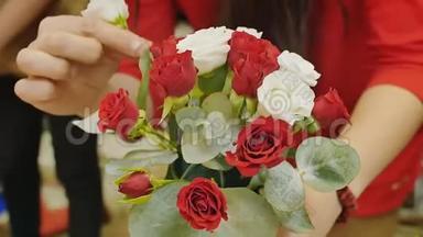 女孩收集一束玫瑰。 准备婚礼，送给女人的礼物。 双手特写