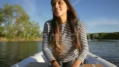 年轻的快乐混合种族女孩划<strong>船充气船</strong>与木桨在湖上。 高清慢动作生活方式录像。