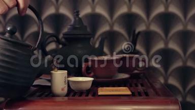 中国传统茶道的动作.. 把茶壶里的茶倒在杯子里，放在竹垫和