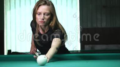 年轻漂亮的年轻女士在一家<strong>俱乐部</strong>里靠在桌子上时，瞄准了斯诺克的<strong>射击</strong>