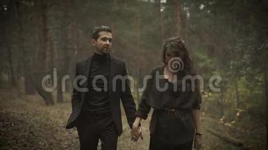 在森林里的小路上，幸福的男人和女人在一起走着。 微笑的夫妇正漫步在
