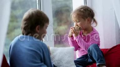 <strong>兄妹</strong>俩坐在窗台上，吃着苹果，看着窗外。