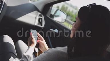 年轻的黑发女孩坐在驾驶<strong>汽车</strong>的乘客座位上。 打电话。 <strong>夏日</strong>晴天