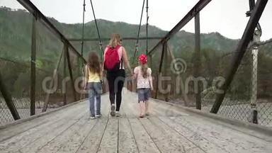 妈妈和<strong>女儿</strong>正在雨中沿着桥走。 <strong>一家人</strong>在山里旅行。 年轻女游客