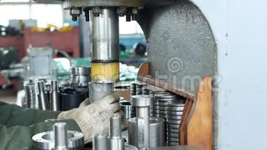 工厂的工人用压轴机将轴承压入轮毂，装配轮毂，装配单元
