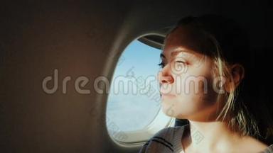 年轻女子<strong>坐飞机</strong>飞行。 <strong>坐</strong>在敞开的窗户前，可以在天空中看到