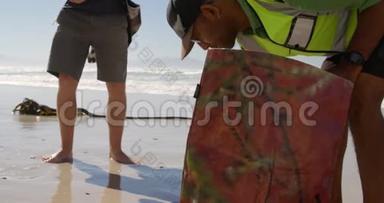 男<strong>志愿者</strong>在阳光明媚的4k天清洁海滩