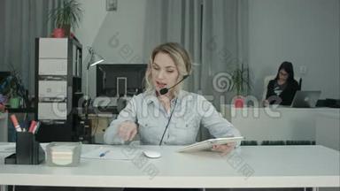 <strong>高效</strong>的电话接线员在与客户交谈时做笔记和使用平板电脑