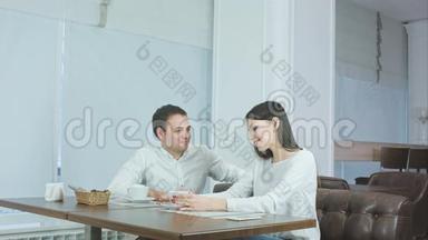 自信的侍者端着沙拉端着桌子，而漂亮的夫妇看着他，微笑着