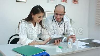两<strong>名医</strong>务人员看着平板电脑上的一些有趣的东西，笑了起来