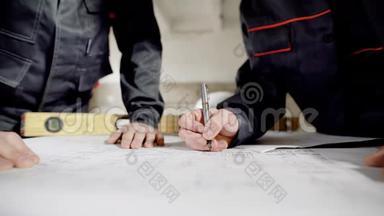 在建筑工人手中的特写镜头，他们在施工文件上作更正，以便绘制图纸
