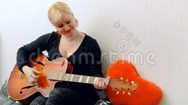 年轻的金发女孩弹吉他