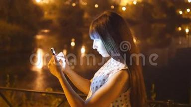 年轻女子晚上玩口袋妖怪去户外，使用智能手机。 女孩玩流行的智能手机游戏-捕捉