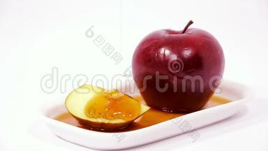 白盘红苹果上浇蜜的照片