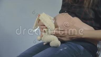 一位孕妇在玩长毛绒玩具摆姿势