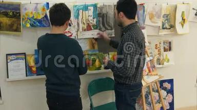 两个年轻人在<strong>艺术</strong>工作室看绘画