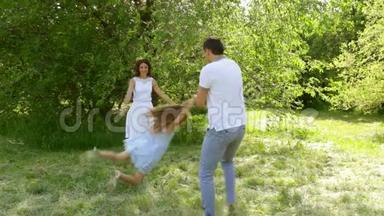 爸爸和女儿在公园里玩耍，爸爸在他的小女孩妈妈跳舞