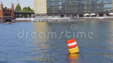 黄、红、白钢在蓝色斯普里河水中的航行浮标