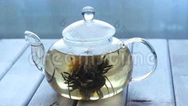 窗前的木制背景上有一个玻璃<strong>茶</strong>壶和中国花<strong>茶</strong>的<strong>视频</strong>