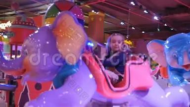 吸引孩子。 小女孩骑着小象旋转木马在<strong>商场中</strong>心的游戏公园。