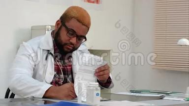 非裔美国人医生在办公桌上填写医疗表格和接听电话