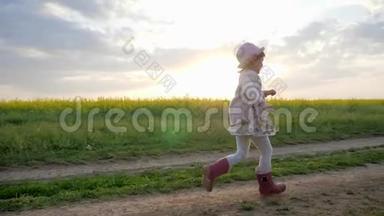 微笑的女孩子，小女孩沿着田间的道路奔跑，奔跑的孩子，快乐的孩子在城外玩耍，健康的孩子