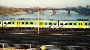 绿色和黄色旅客列车在<strong>铁路大桥</strong>上横渡河的空中拍摄。 4K视频