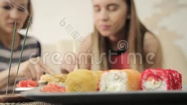 两个女朋友在餐馆吃饭时互相喂饭，用筷子吃面包