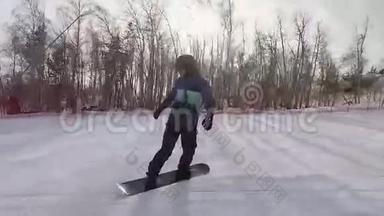 人在滑雪板上迅速地从山上走出来。 他的身体受到特殊设备的保护-黑帽子，太阳镜