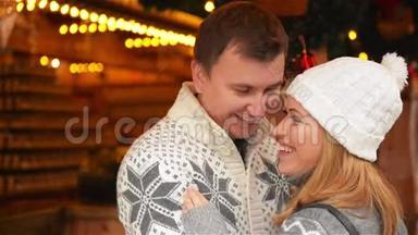 幸福的年轻夫妇一起穿着温<strong>暖</strong>的衣服，在后台庆祝<strong>圣诞节</strong>，在<strong>圣诞节</strong>欢笑