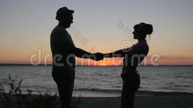 年轻夫妇在<strong>夏季</strong>海滨度过<strong>周</strong>末，在日落时分亲吻恋人们到海边的河流，浪漫的爱情之旅，