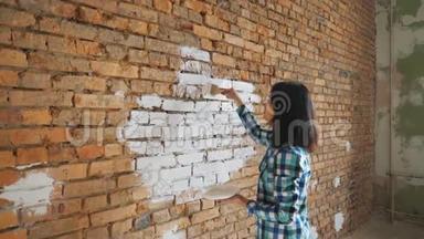 漂亮的年轻女人在做墙画。