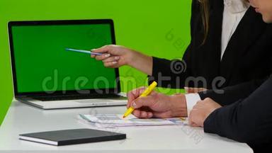 办公室的桌面上有重要的图表。 绿色屏幕笔记本