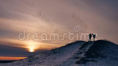 人冬天剪影做自拍拍照欢乐雪阳光.. 一群游客走在夕阳的剪影之上