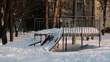 雪天晴冬季城市公园里的滑板车登机公园.. 雪在山上漂移到滑板上。